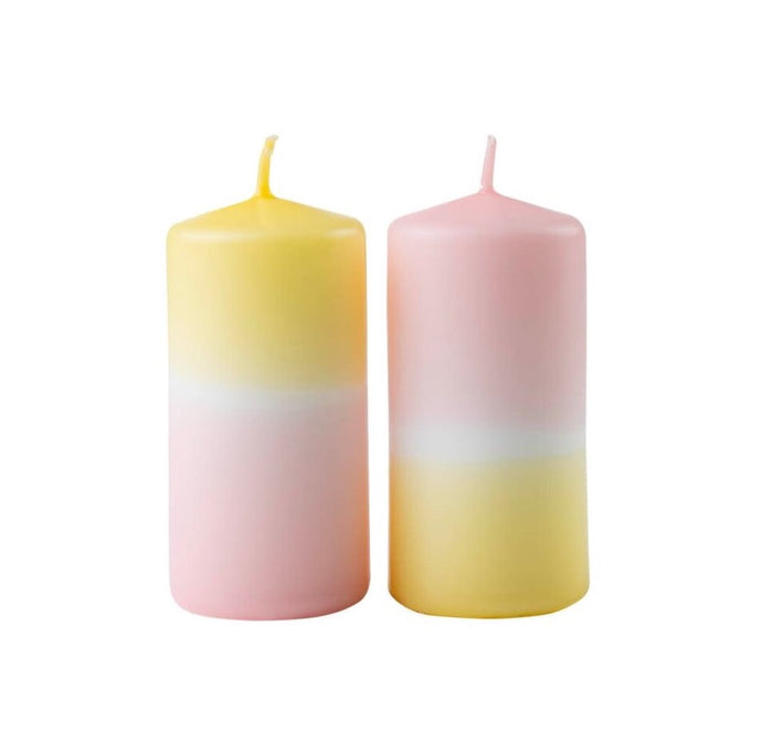 Twee kaarsen die om en om geel en roze van kleur zijn.